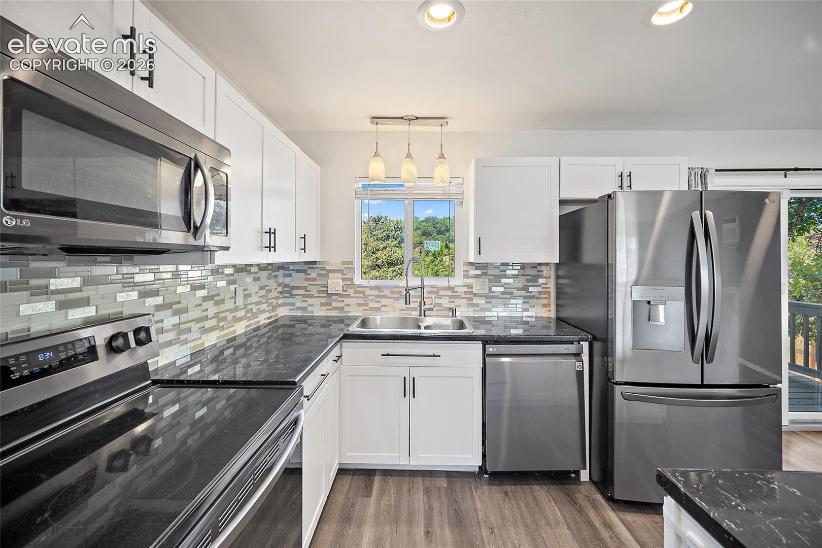 Kitchen with white cabinetry and tile backsplash.