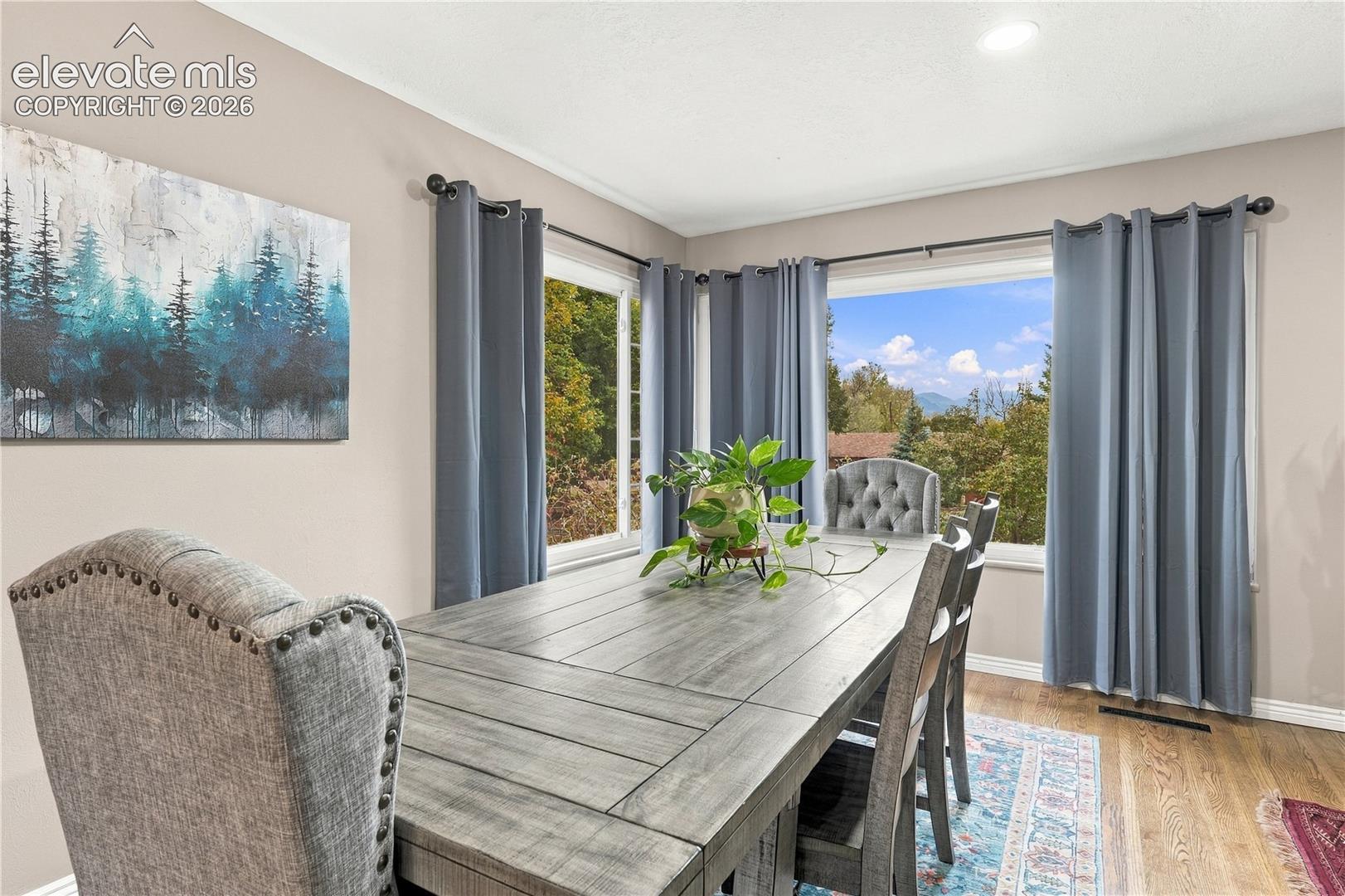 Corner window configuration featuring natural light, wood-finish flooring, and expansive mountain scenery
