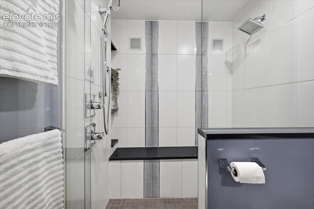 Enclosed Steam Shower with a built-in speakers, dual shower heads, and an integrated toiletry shelf