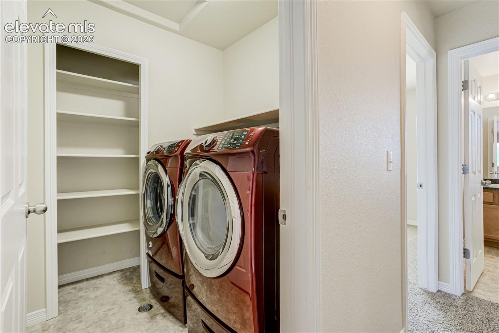 Utility room with built-in shelving, a wood-finish counter, and light-toned flooring. Washer/Dryer included.