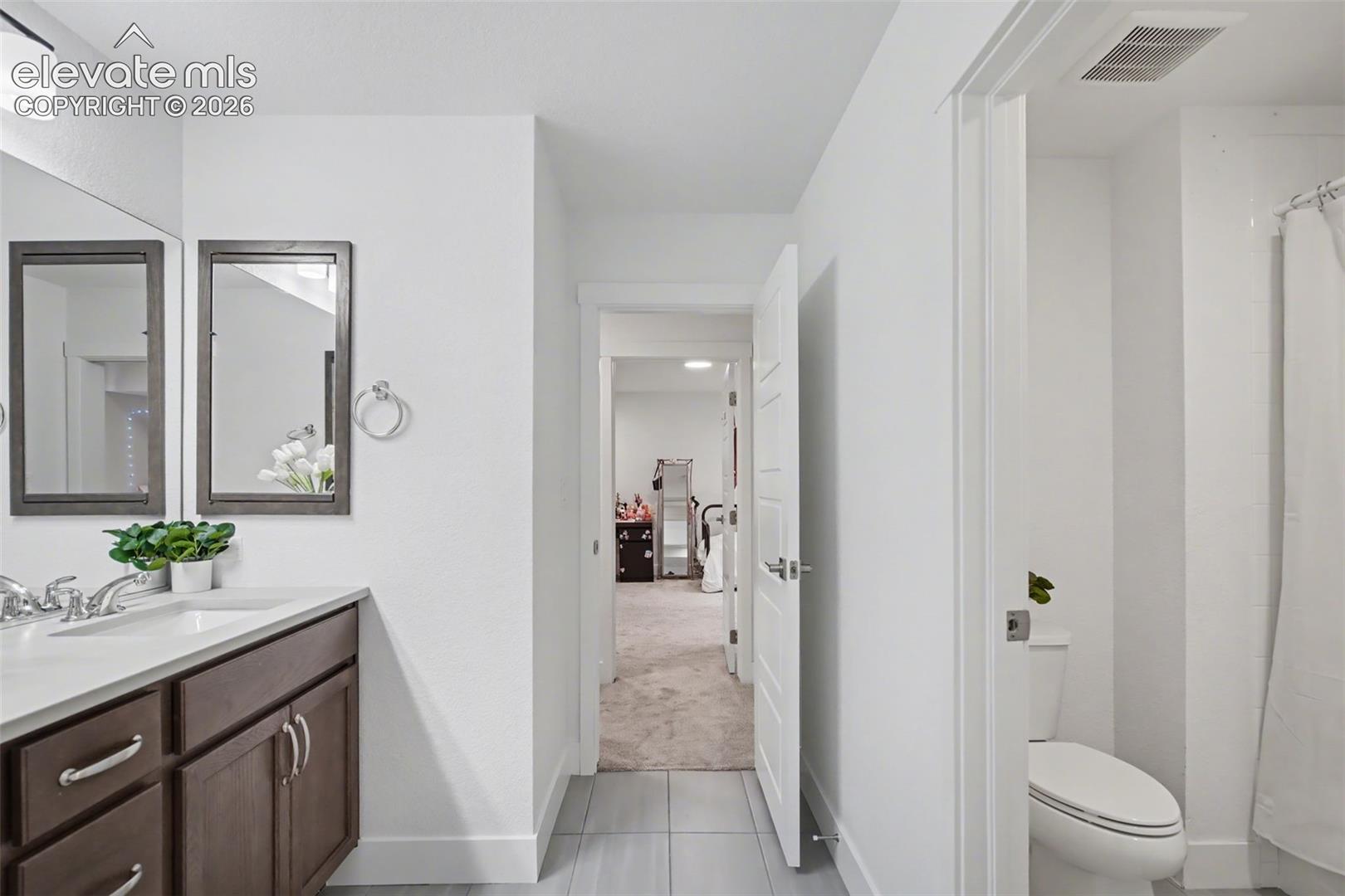Bathroom with vanity, a shower, light carpet, and light tile patterned floors