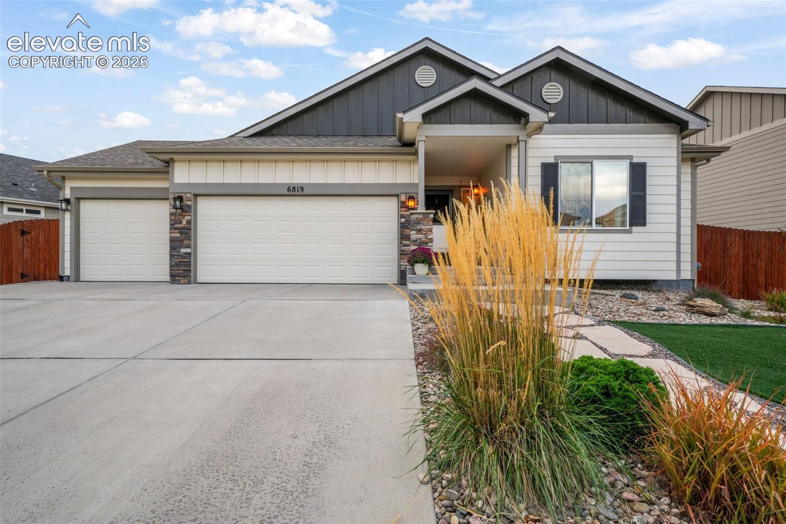 Exterior featuring a two-car garage, stone accents, and a covered entry