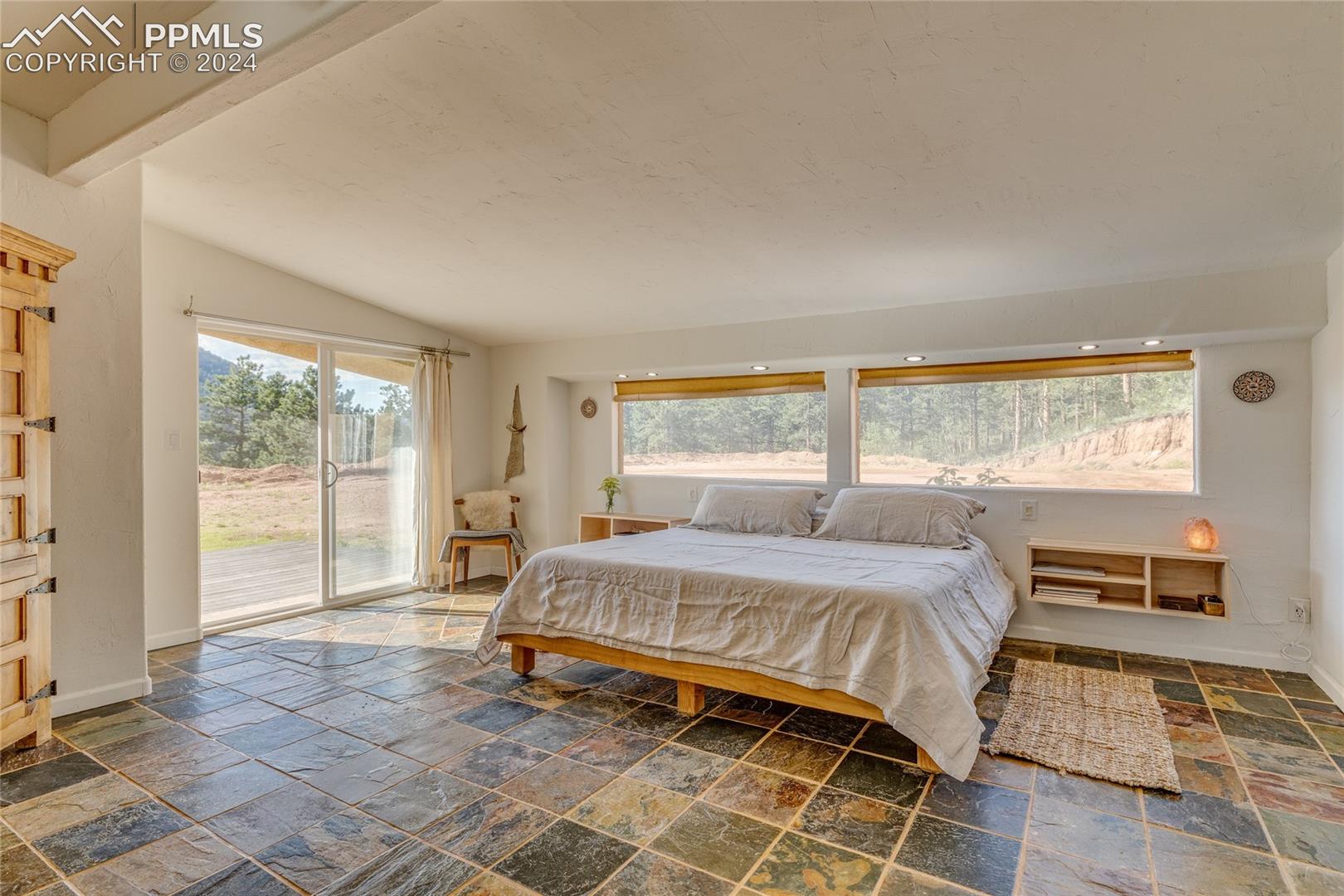 Bedroom featuring tile flooring, access to exterior, and lofted ceiling with beams