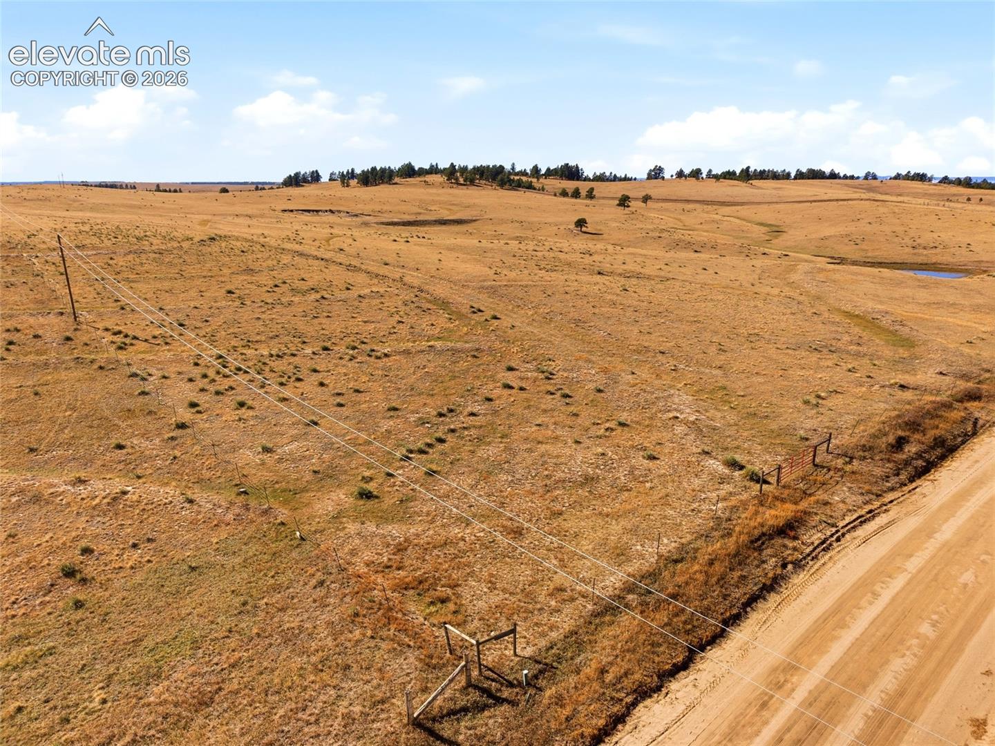Expansive acreage featuring rolling topography, open pastureland, and perimeter fencing