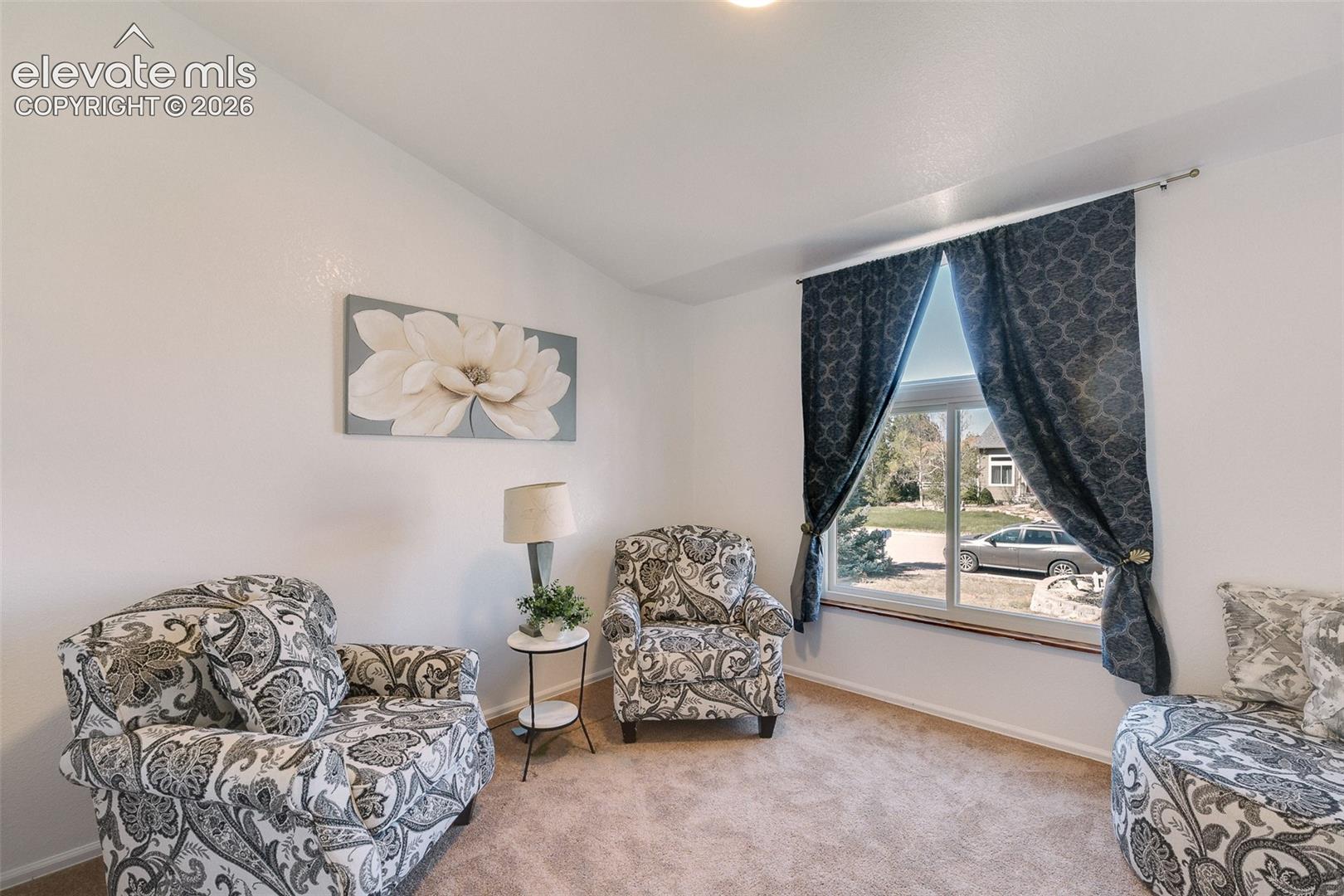 Main level Bedroom #3 has neutral carpet and front yard views.