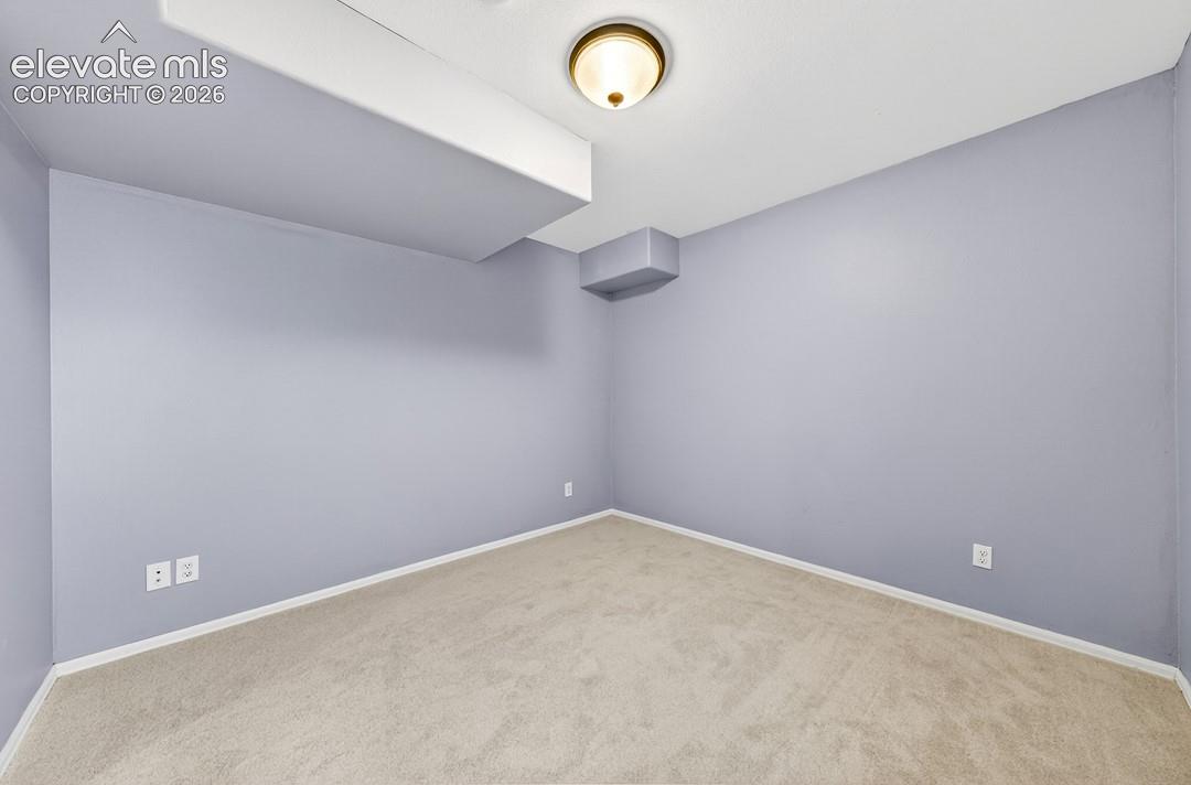 Neutral-toned wall paint, wall-to-wall carpeting, and a flush-mount dome light fixture