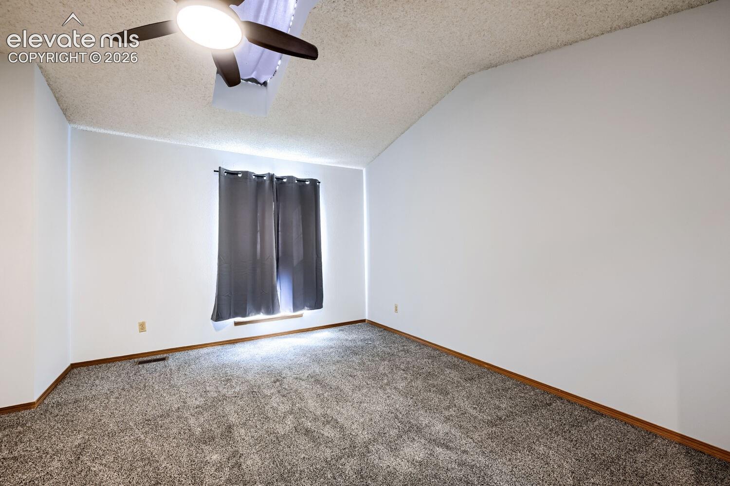 Vaulted ceiling with an attached ceiling fan and light fixture