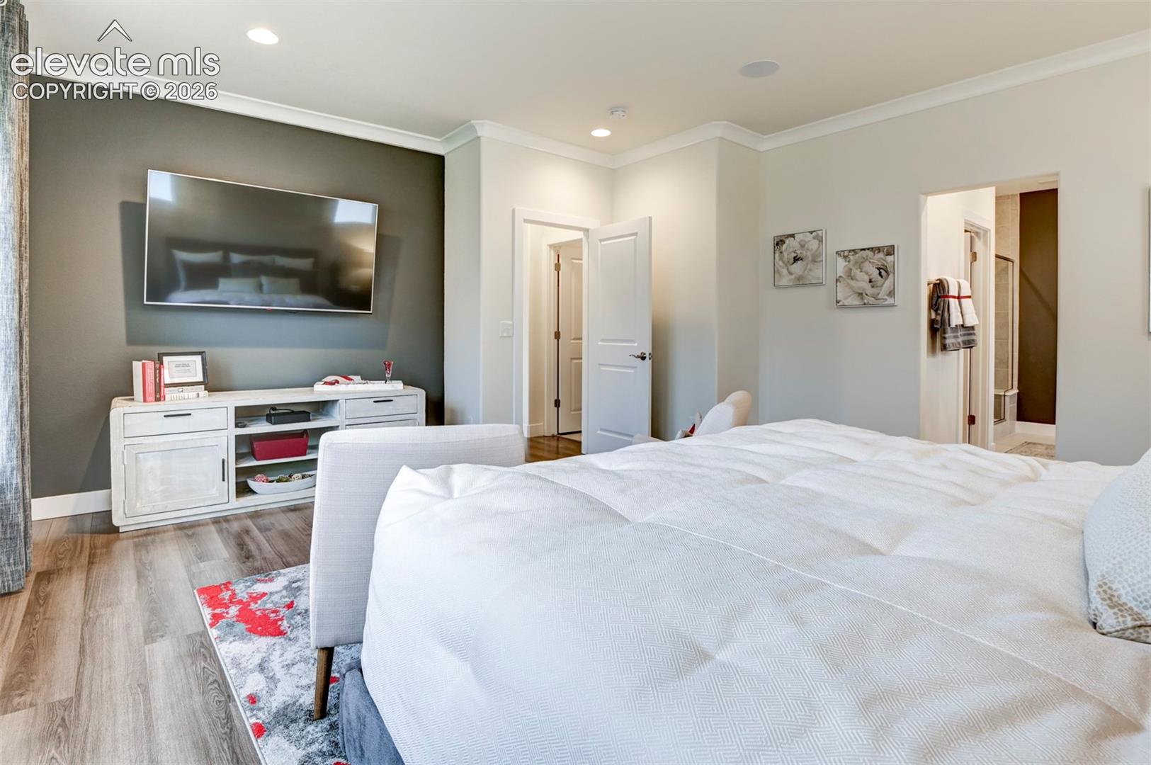 Recessed lighting, crown molding, wood-finish flooring, and a wall-mounted television