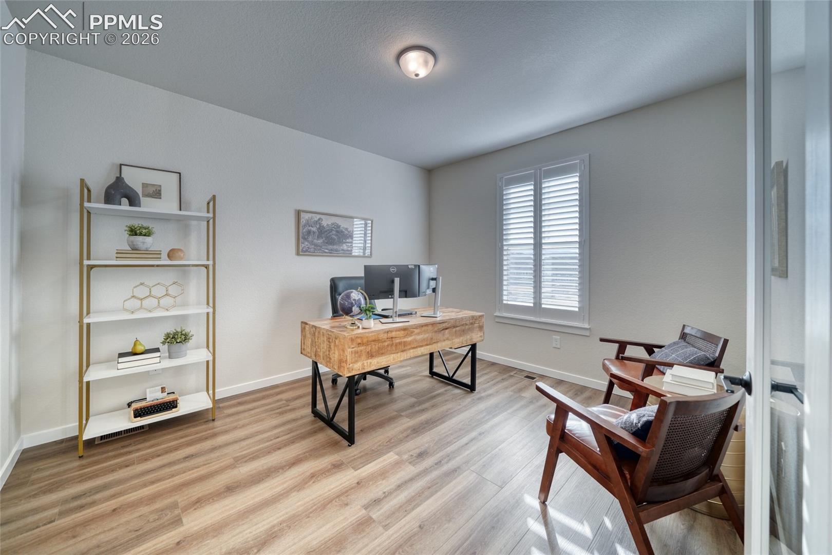 Office space with baseboards and light wood-style flooring