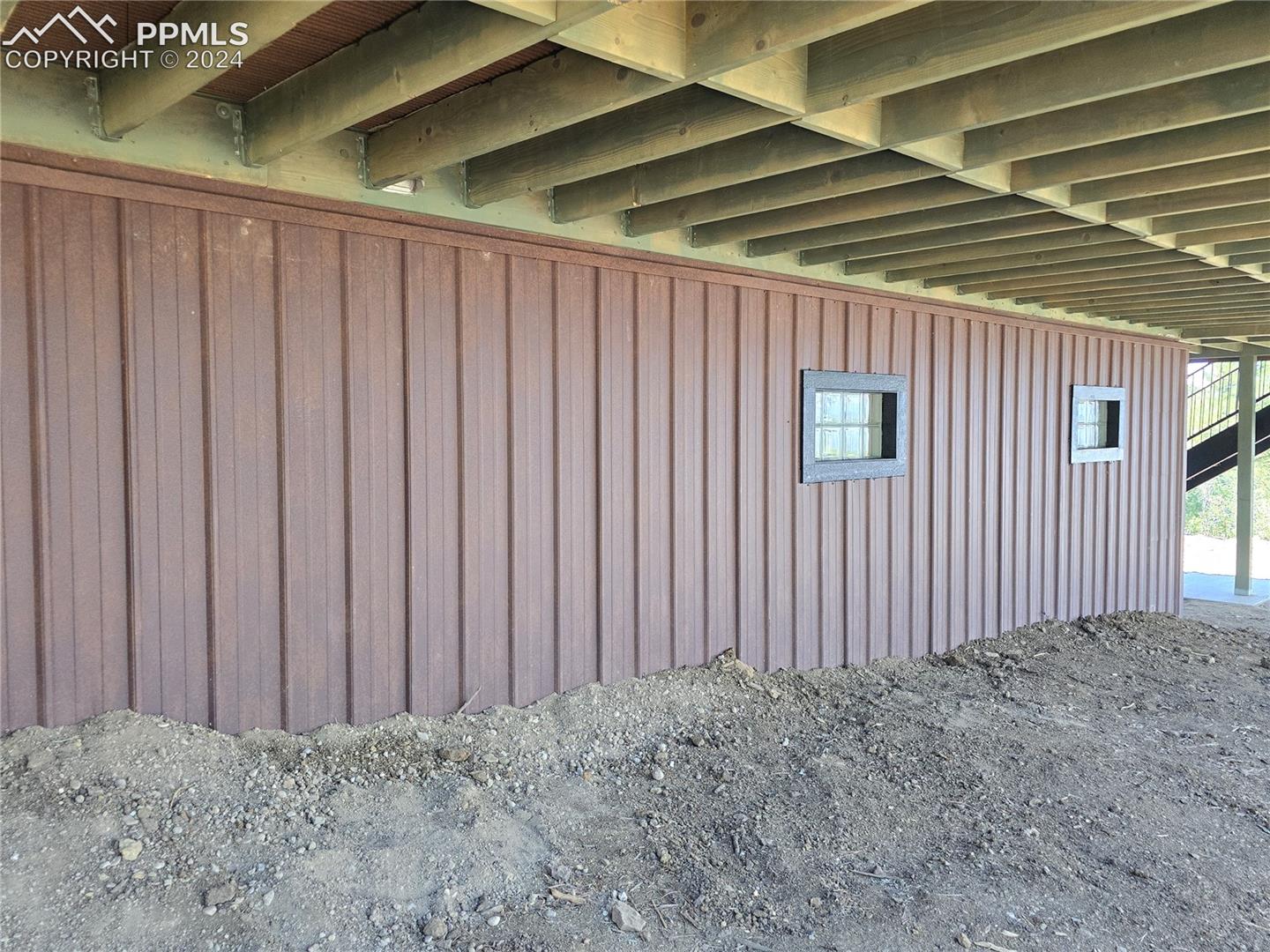 View of home's exterior with rusted steel siding over ICF foundation
