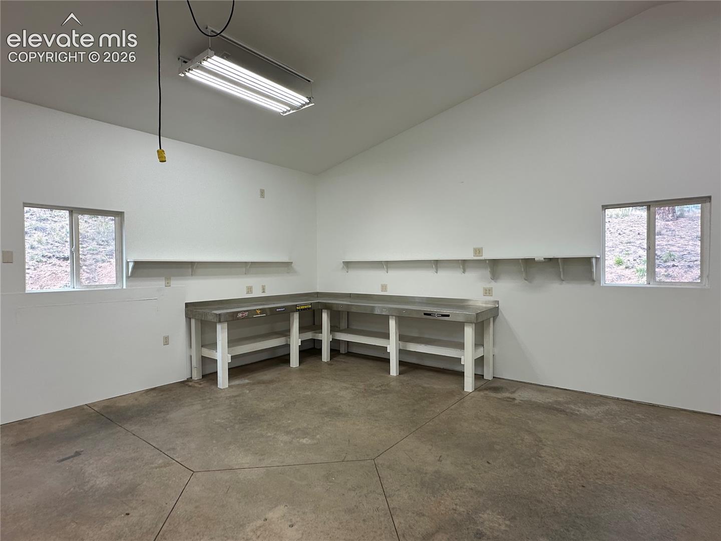Workbenches and ample electrical outlets. Concrete floor. Excellent lighting.