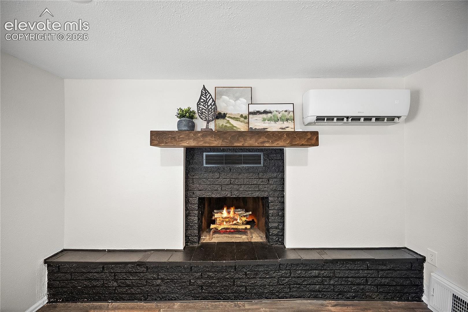 Fireplace featuring a black brick surround, wood-finish mantel, and an elevated hearth