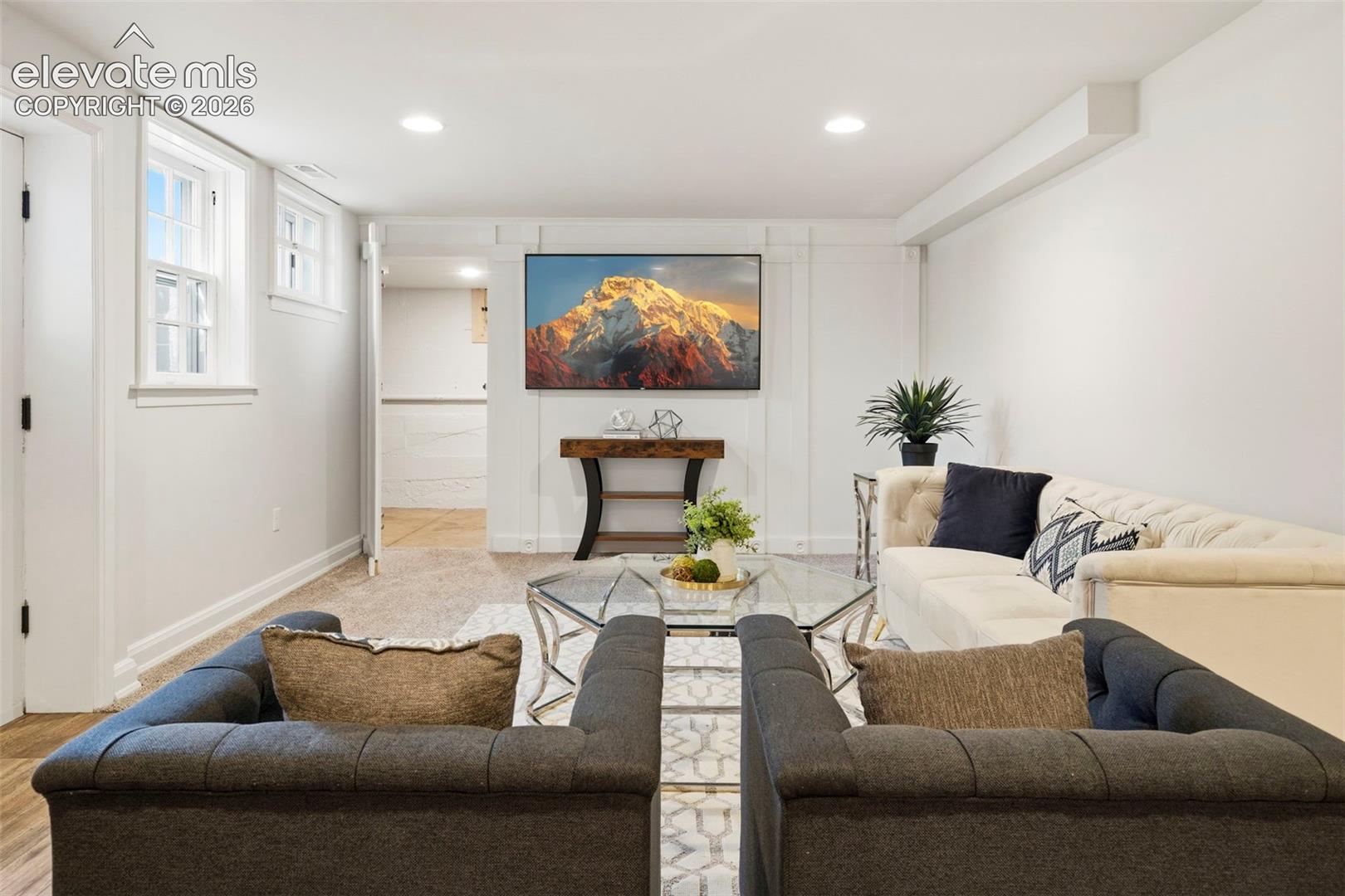 Interior space featuring crisp white walls, wainscot detailing, recessed lighting, and wall-to-wall carpeting