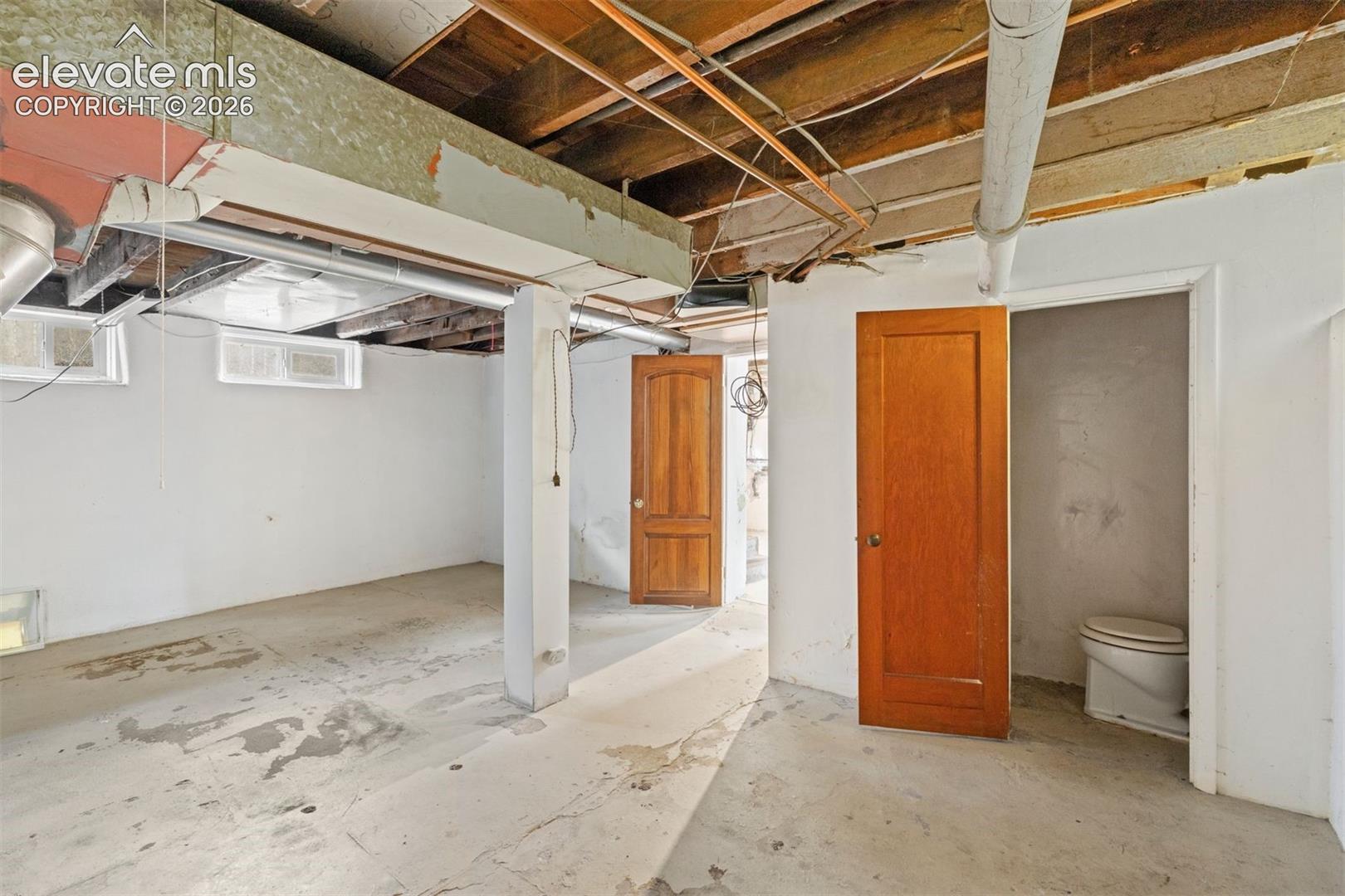 Unfinished basement area with 1/2 bath