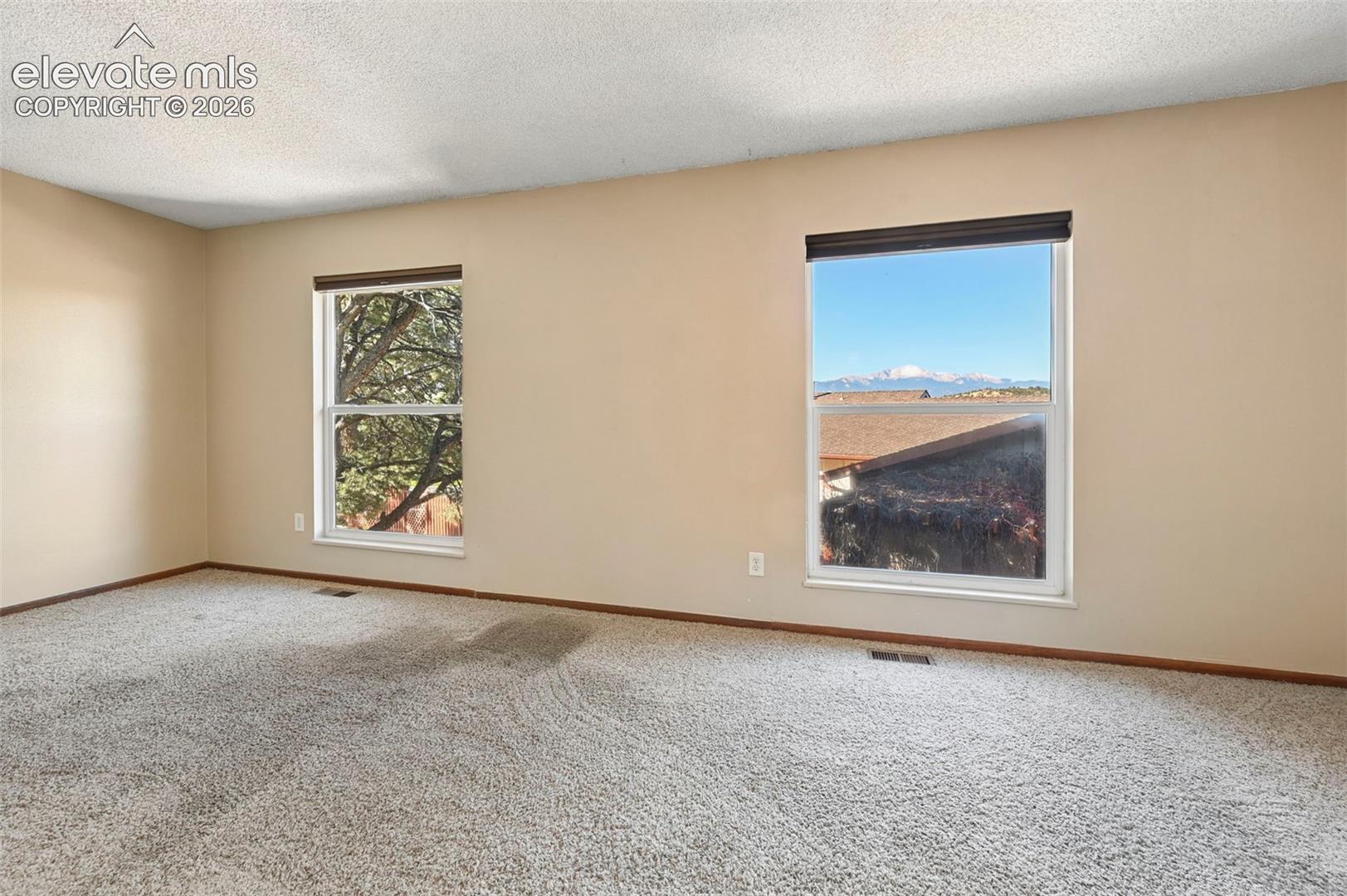 Neutral-toned interior featuring dual windows and mountain scenery