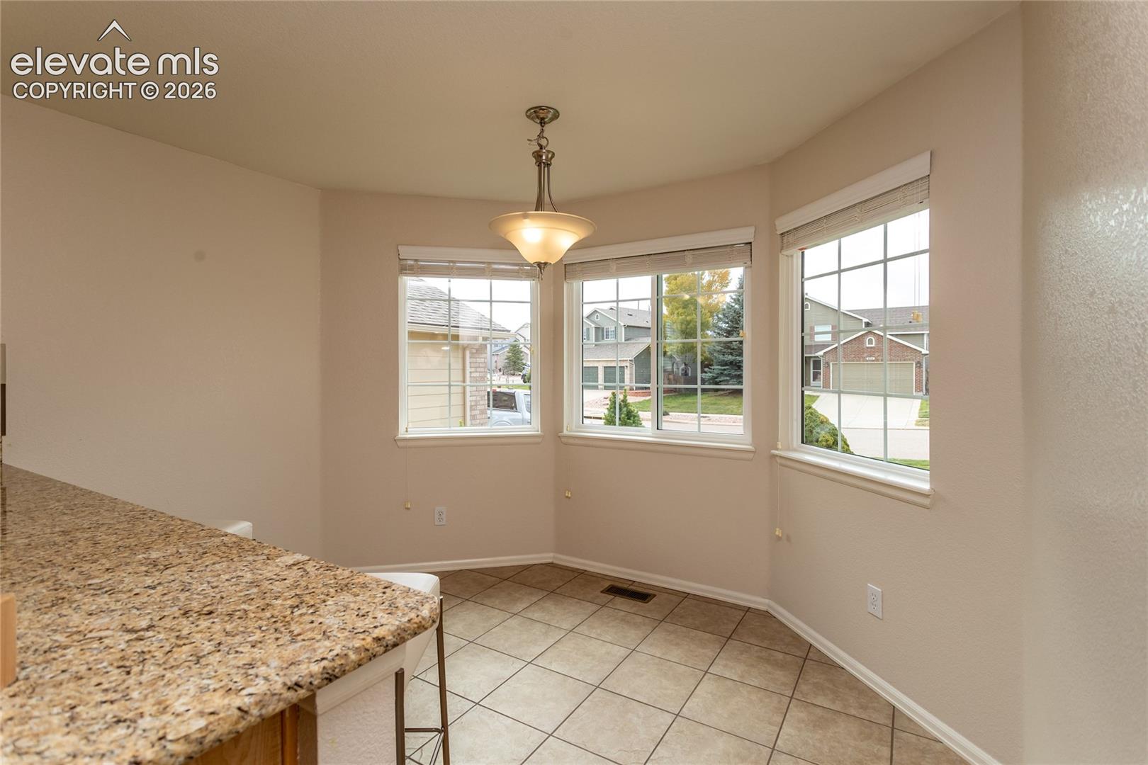 Bay window breakfast nook featuring tile flooring.
