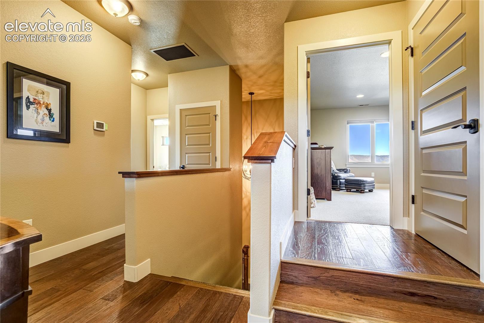 Substantial millwork, warm wood flooring + distinctive interior doors carry the home's custom design vision through the upper-level hallway, connecting the private living spaces with architectural continuity.