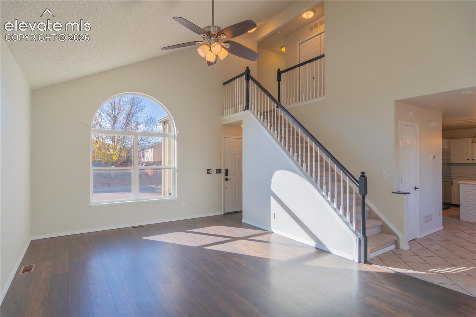 A dramatic arched window and contrasting staircase railing highlight the home's architectural charm.