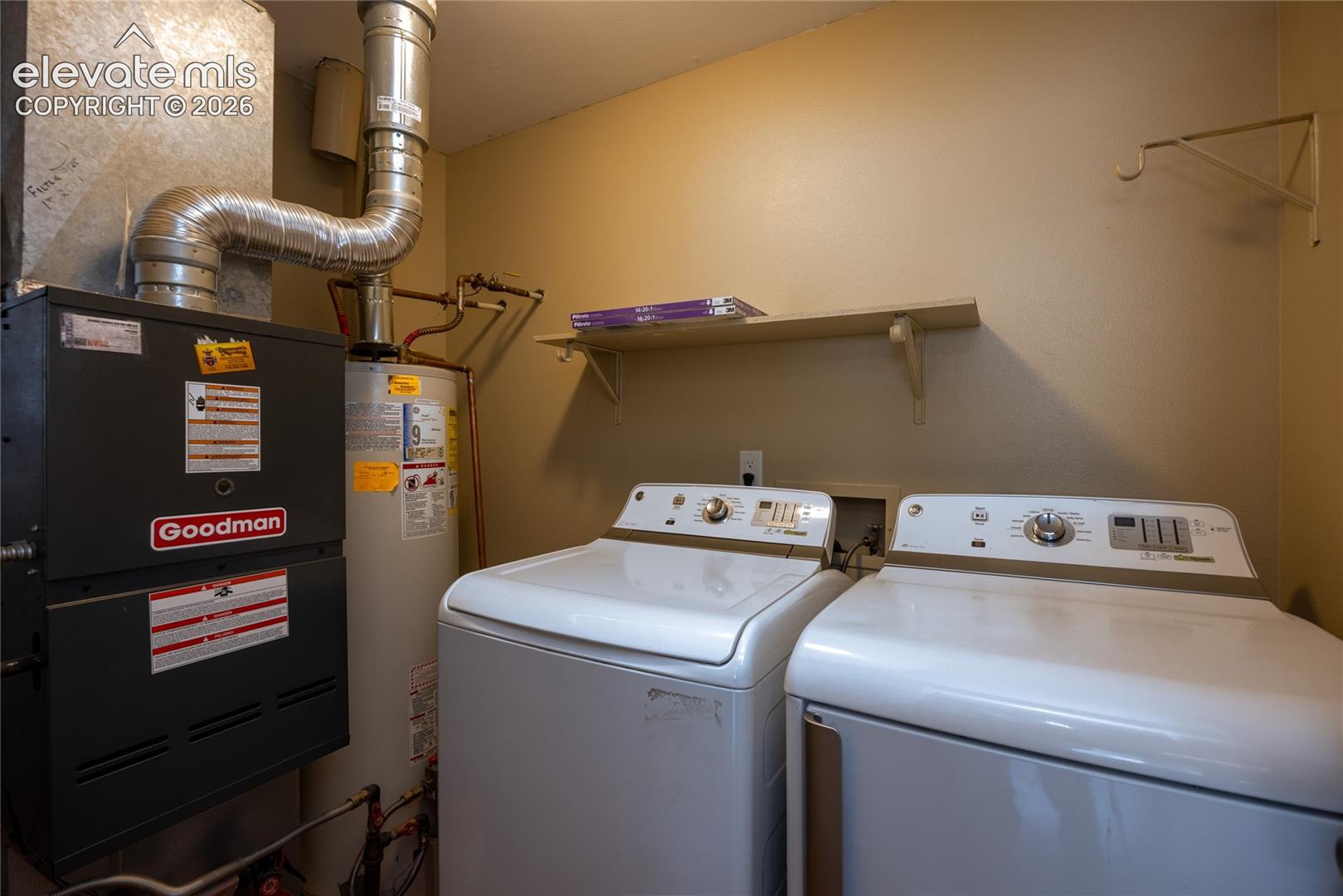Utility area with water heater, furnace, and wall-mounted shelving