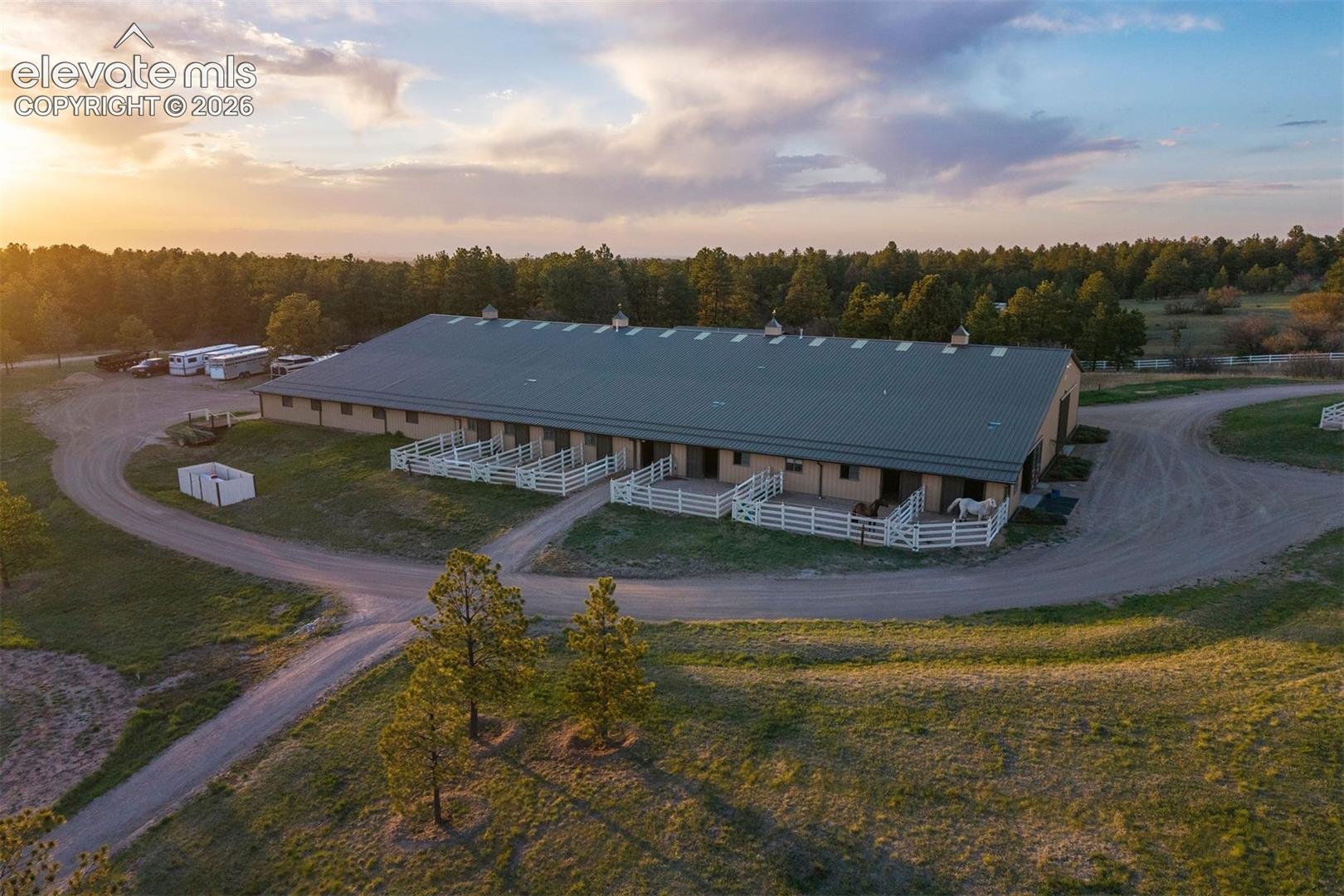The equestrian facility features a 20-stall barn with heated stalls, three tack rooms, an expansive indoor arena, a spacious outdoor arena, and 11 paddocks.