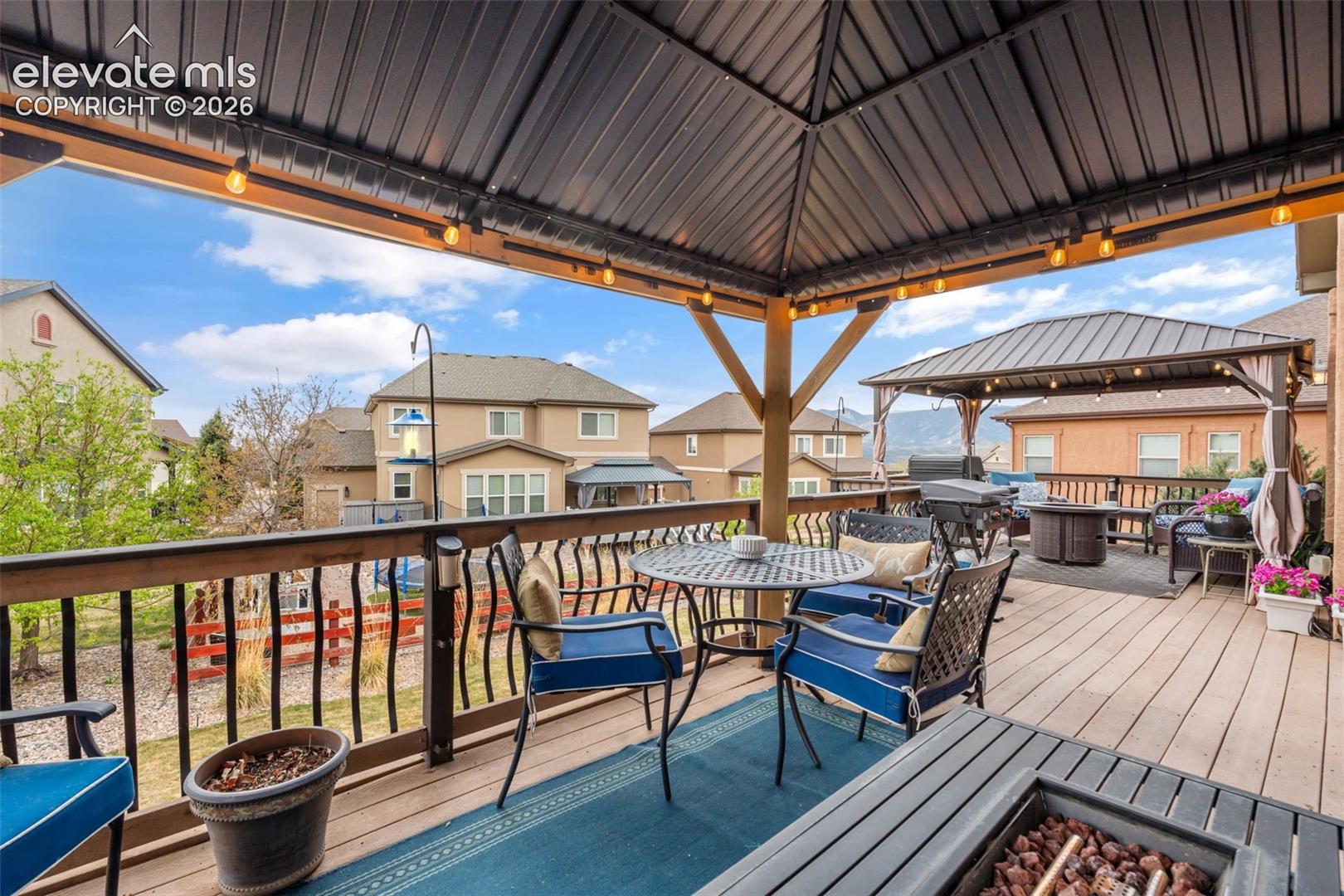 Spacious multi-level deck featuring a primary covered pergola with string lighting