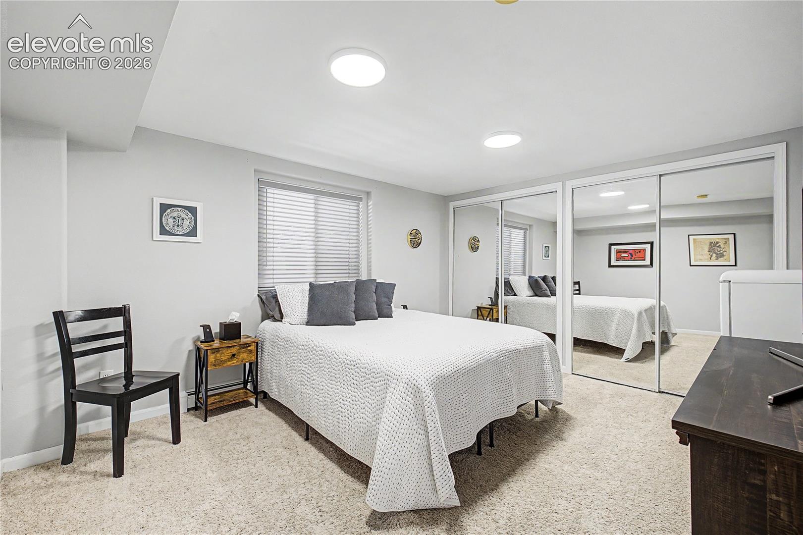 Even on the lower level, a window well brings in natural light, keeping this bedroom feeling open and bright rather than tucked underground.