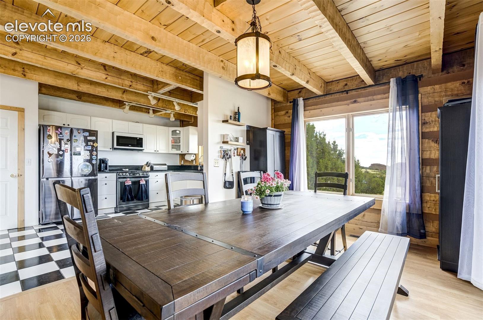 Exposed wood beam ceiling and wood plank wall paneling define this dining area