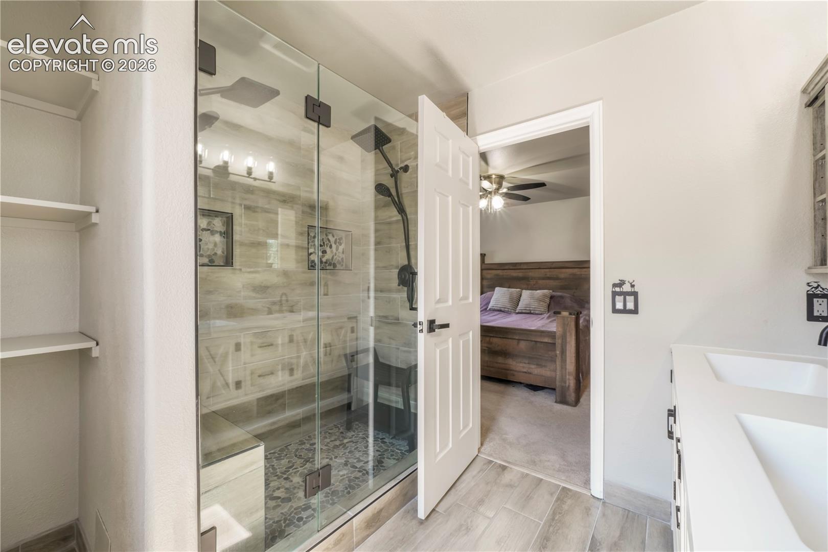 Upstairs primary updated bathroom with large walk in shower and dual vanties