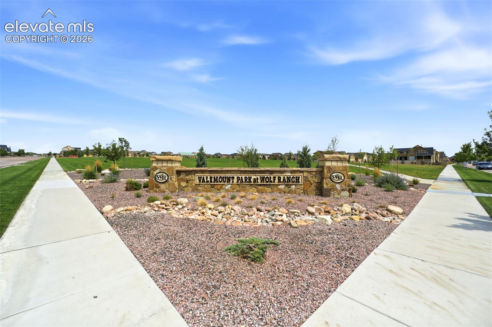 Stone-clad community entrance sign with integrated landscaping