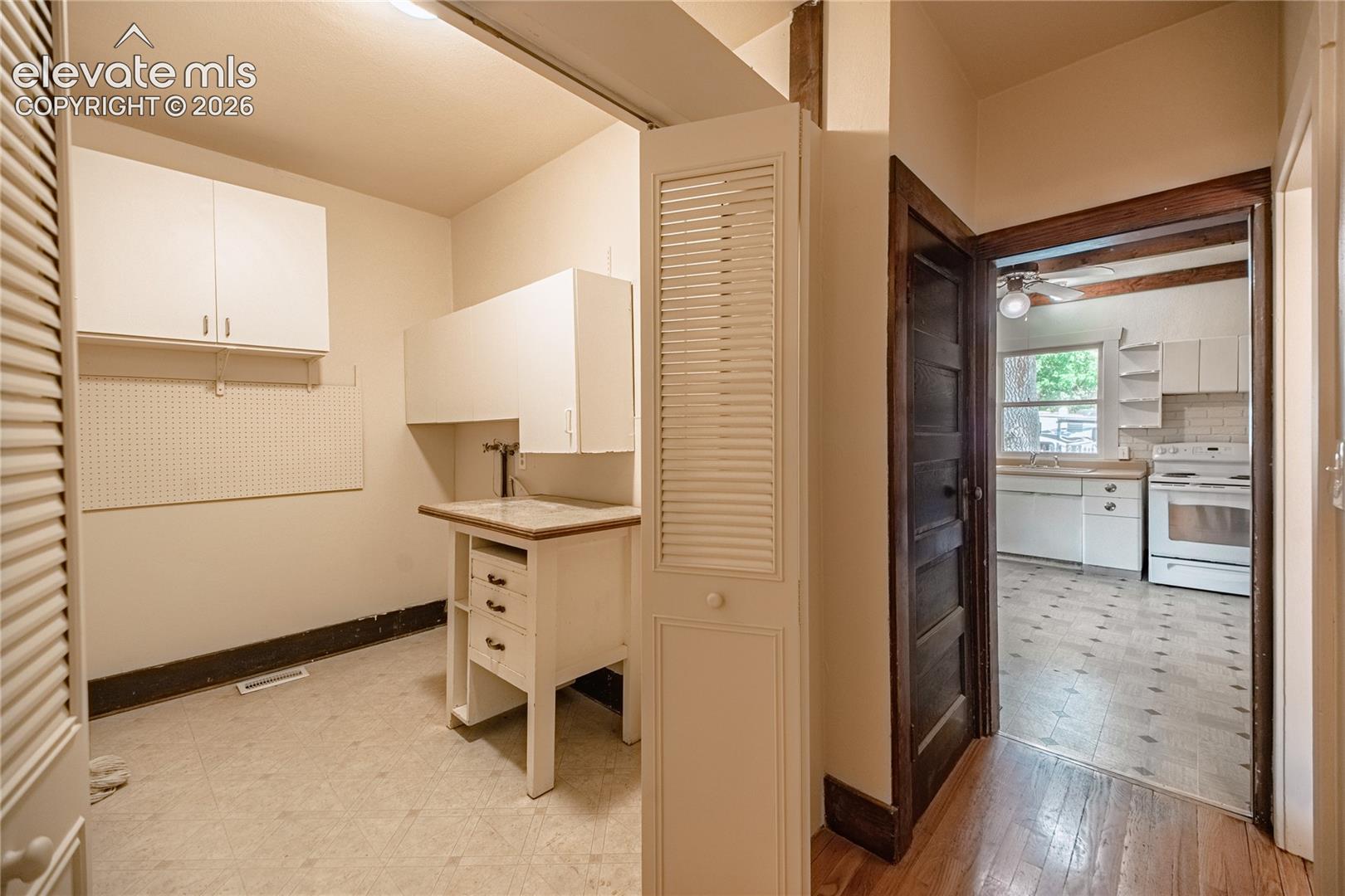 Dedicated utility area featuring a built-in sink and upper cabinetry