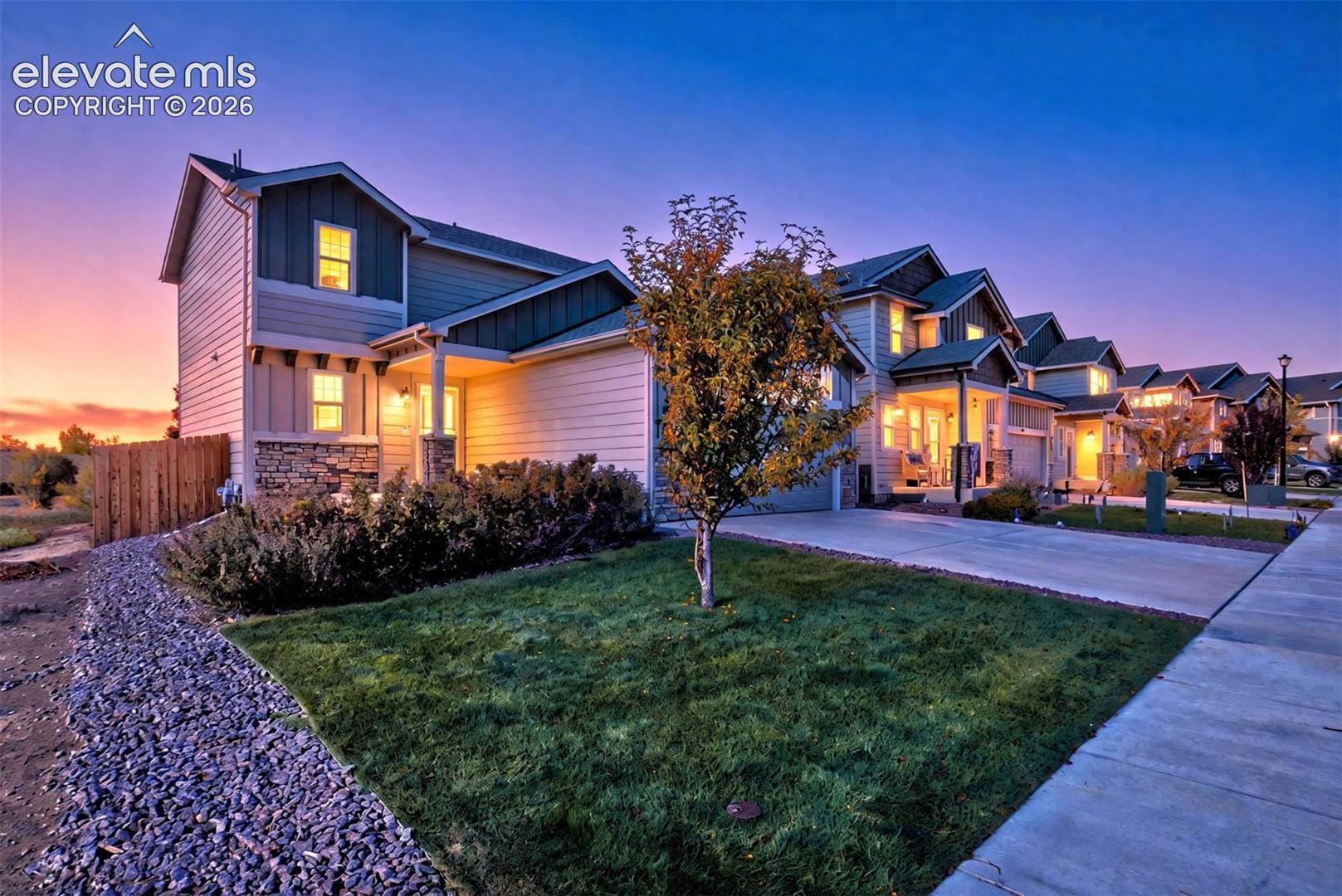 Exterior facade featuring horizontal lap siding, vertical board-and-batten accents, and stone veneer foundation detailing