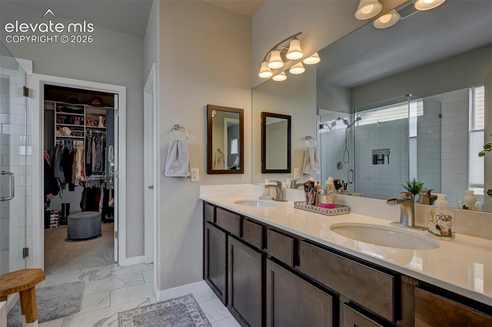 Double vanity with white countertops and dark wood-finish cabinetry