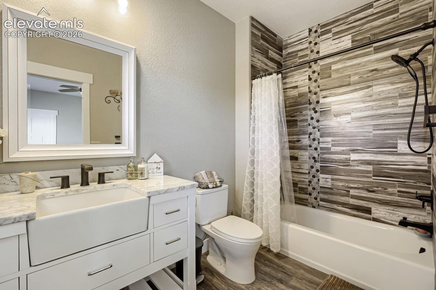 White shaker vanity with farmhouse sink and dark bronze fixtures