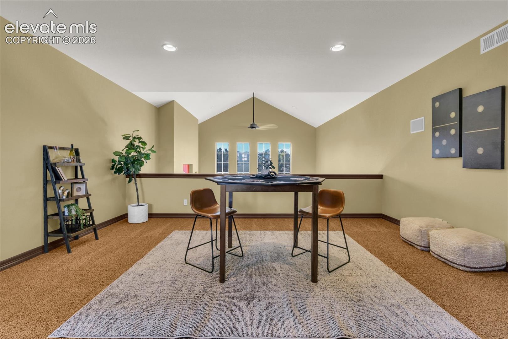 Vaulted ceiling, four-pane vertical window configuration, recessed lighting, and wall-mounted ceiling fan