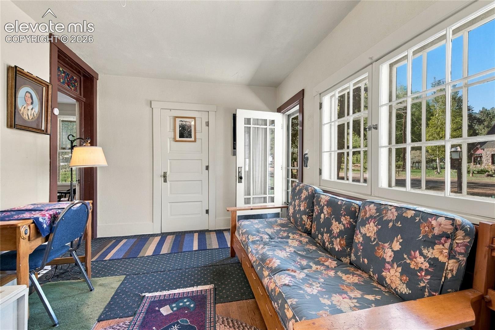 Framed front porch with windows provides ample light. Door leads to a private office or bedroom. Brown door with stain-glass window leads to the foyer and sitting room. 