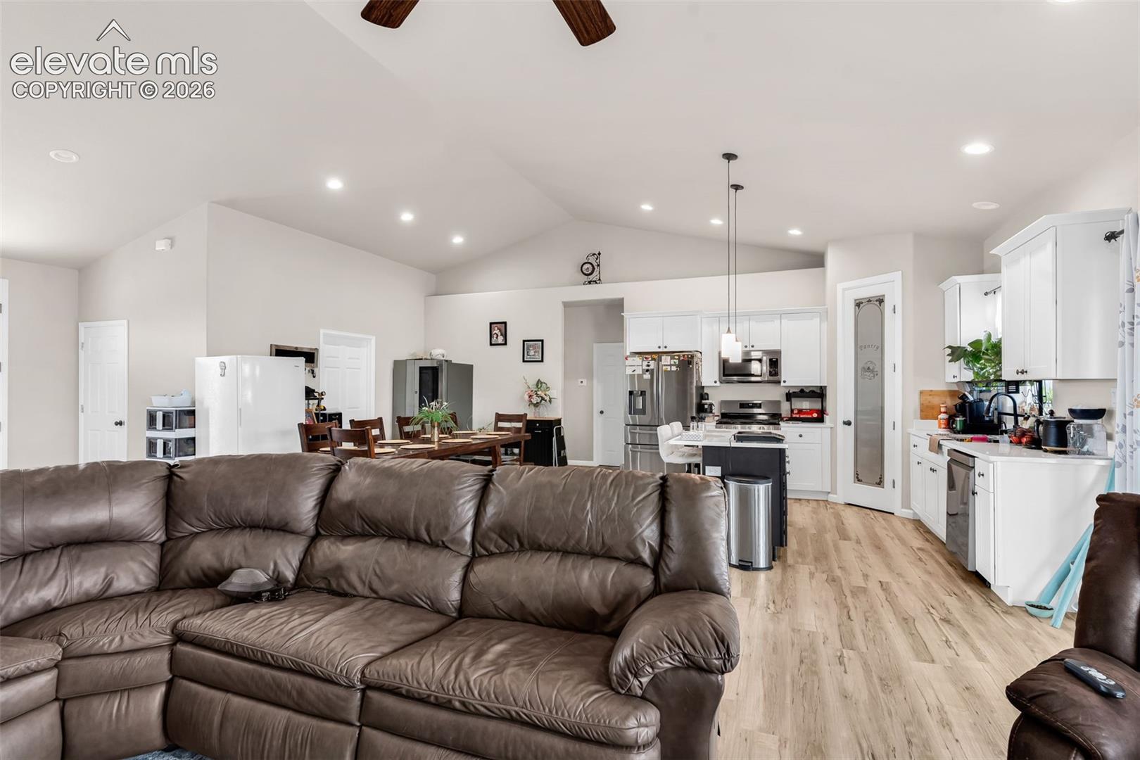 Open-concept living area with vaulted ceilings and wood-finish flooring