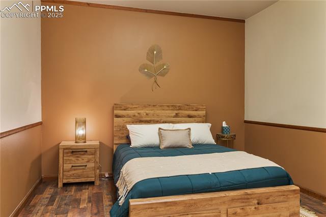 Bedroom with baseboards and wood finished floors