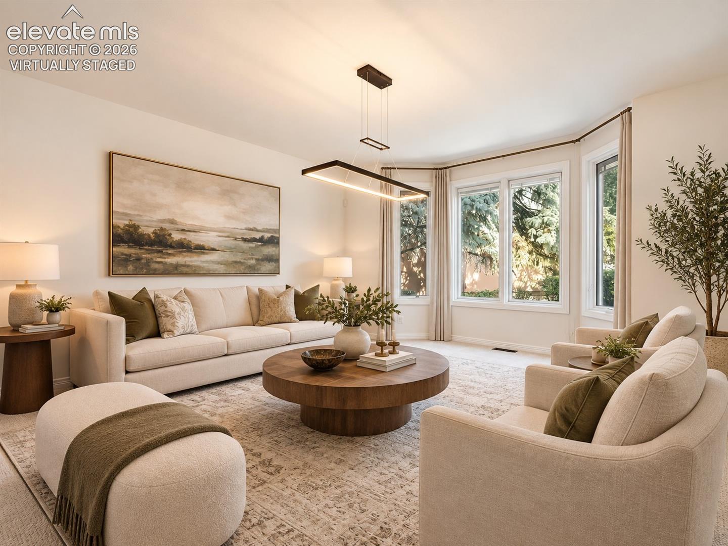 Living area featuring a bay window, neutral wall paint, and a modern rectangular linear pendant light fixture- virtually staged