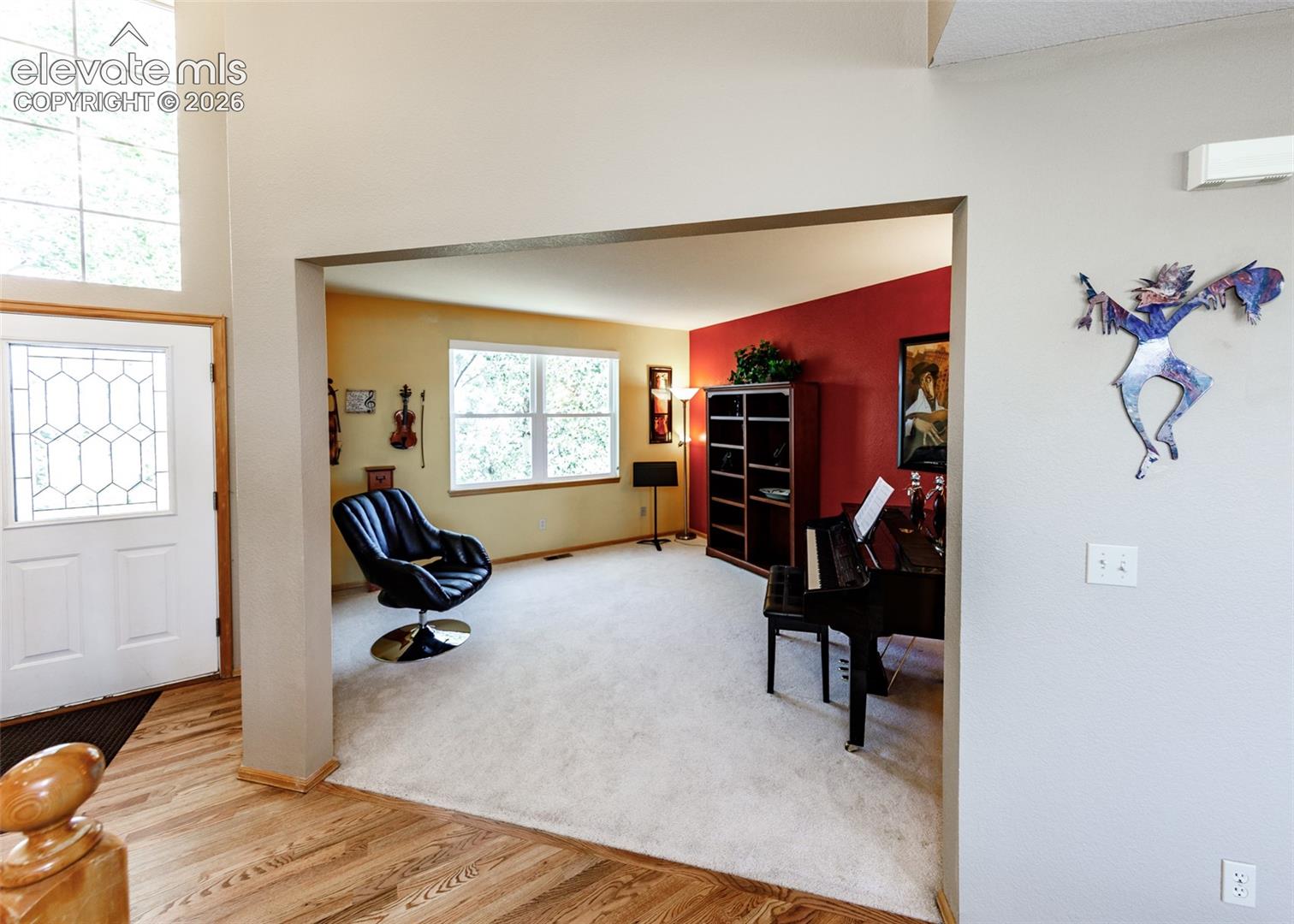 Entryway featuring wood-finish flooring, a decorative glass-paneled door, and a transom window