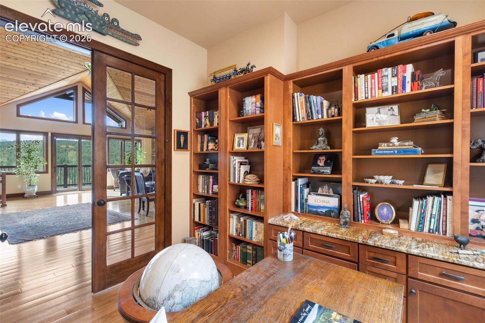 Office with built ins and book shelves, french doors. 
