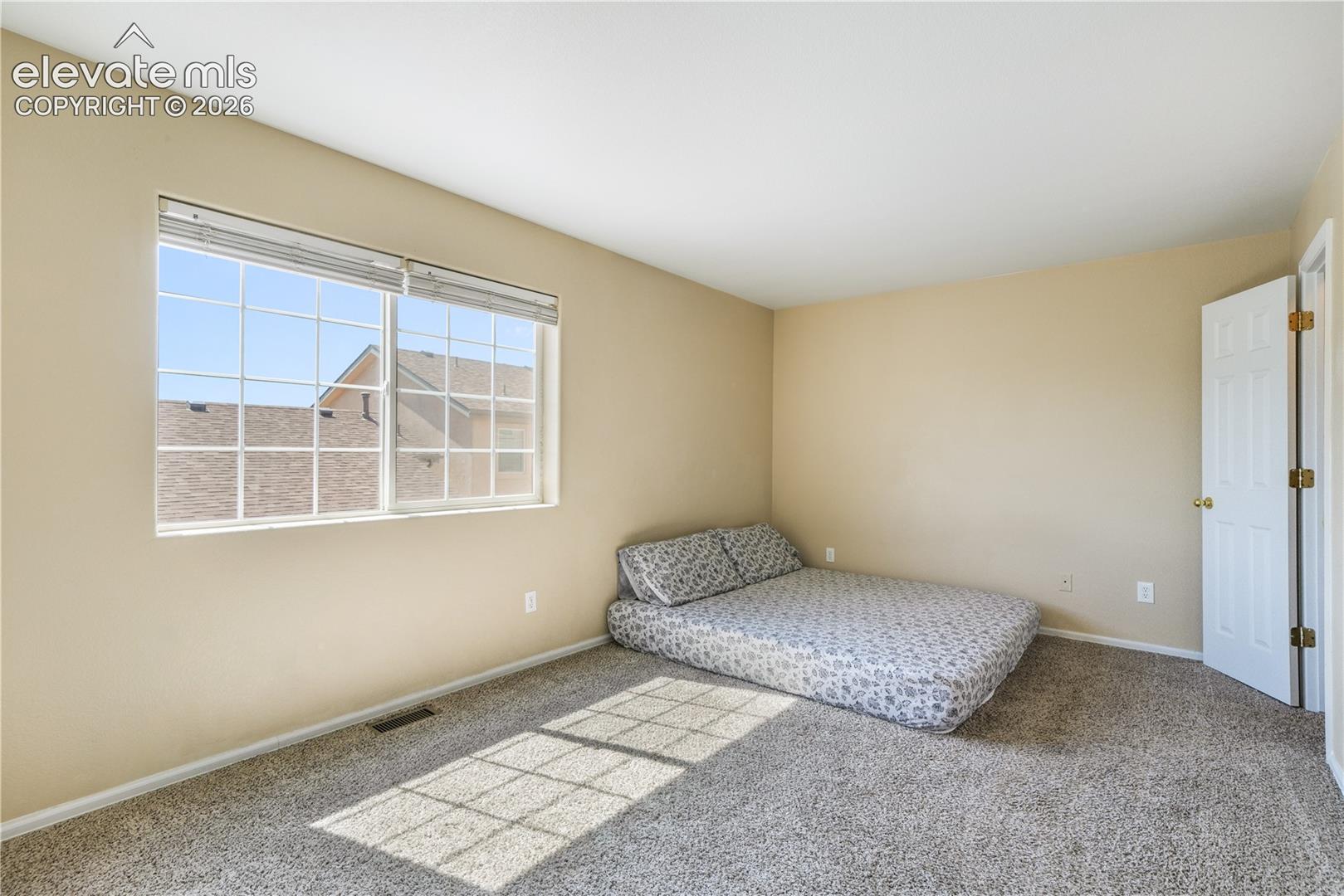 Main level primary bedroom with walk in closets and ensuite bathroom with 2 vanities, 2 separate showers