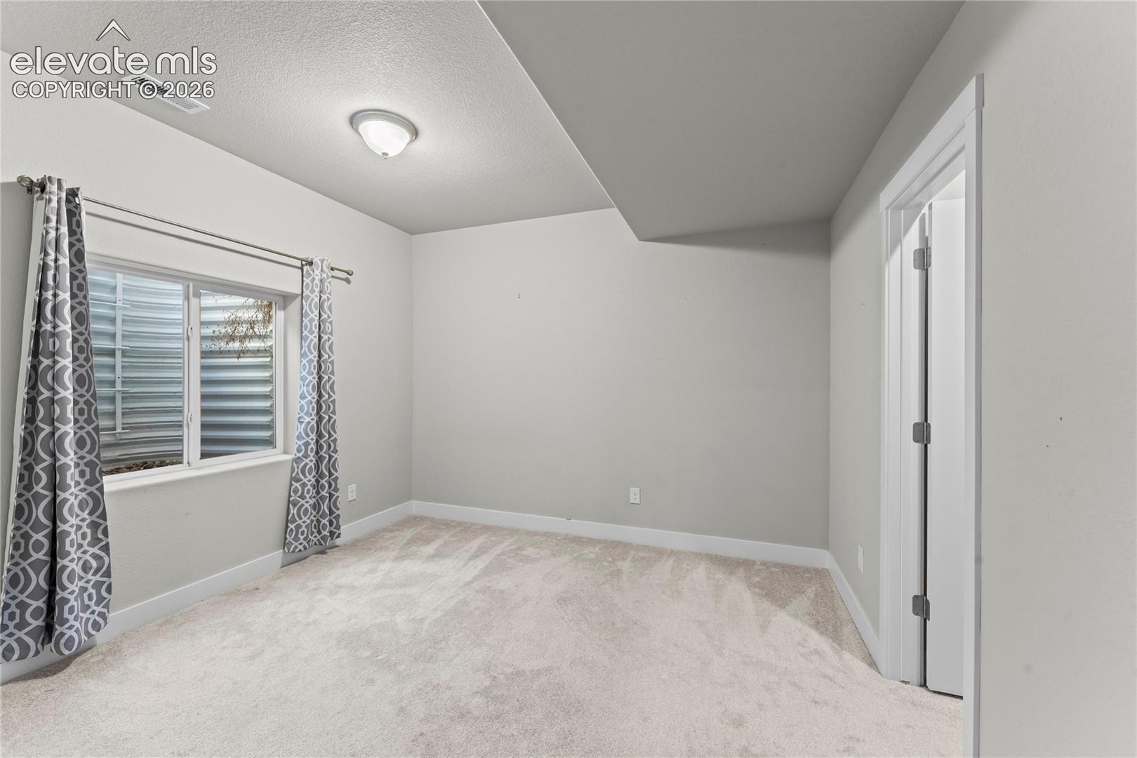 Recessed window with white trim, wall-to-wall carpeting, and a flush-mount ceiling light fixture