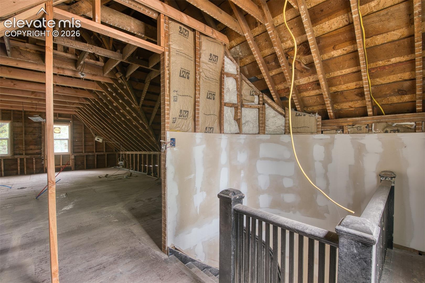 Curved staircase leads to upper level waiting for a potential build out of a studio style apartment or large bedroom suite. 
