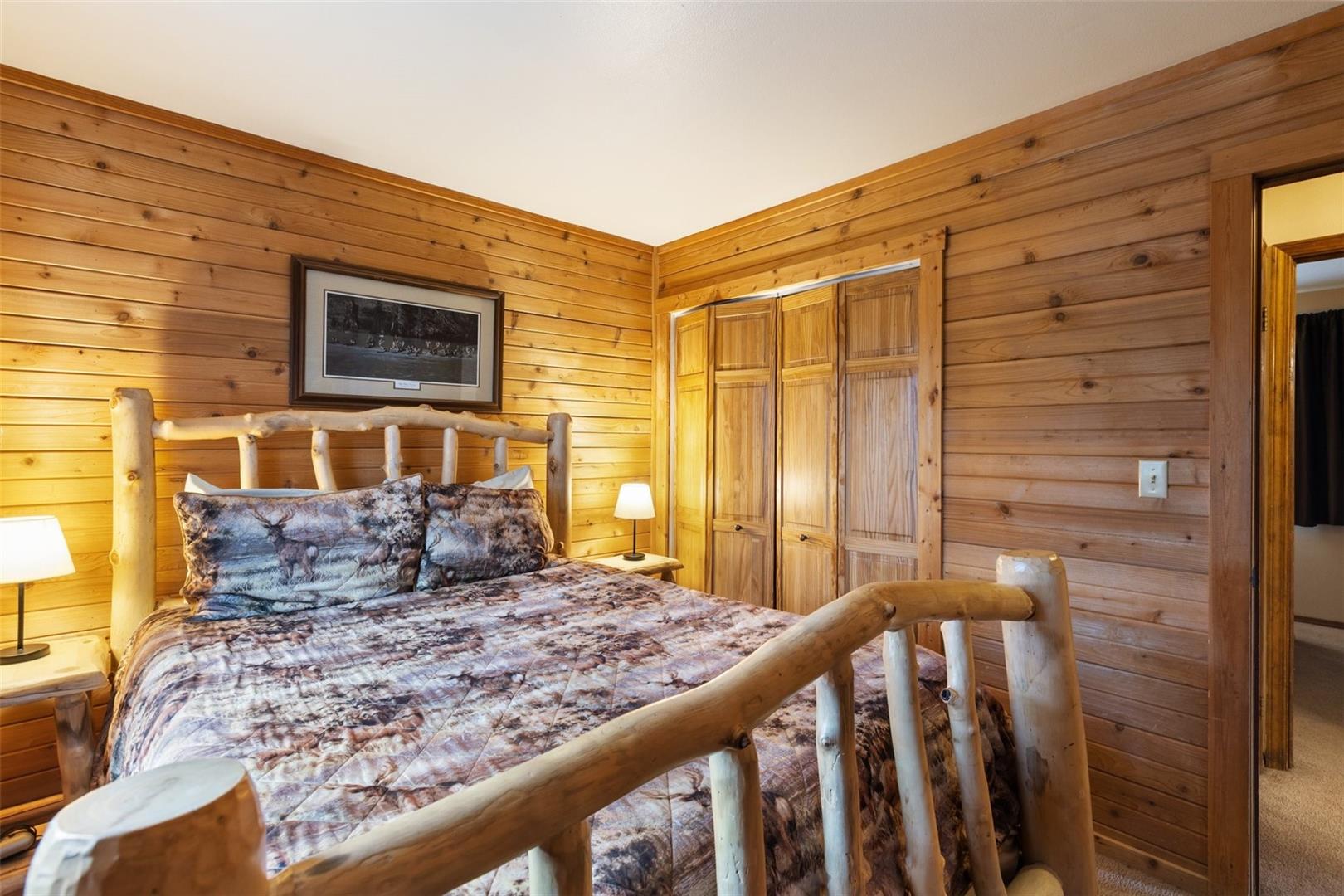 Wood-paneled walls with natural grain, wood-finish bi-fold closet doors, and wood-finish trim