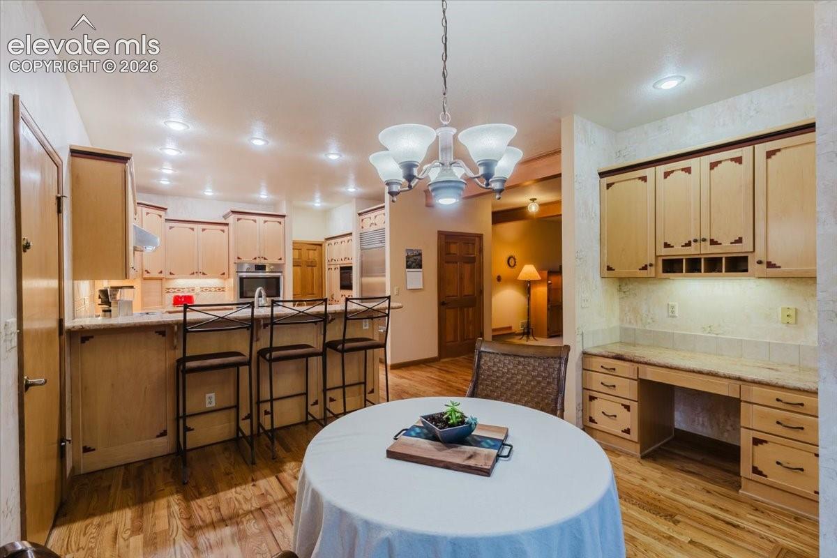 Kitchen and dining area featuring hard wood flooring, recessed lighting, and a chandelier