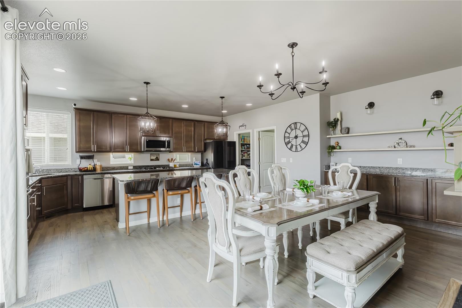 Open-concept living space featuring wood-finish flooring, recessed lighting, and a neutral color palette