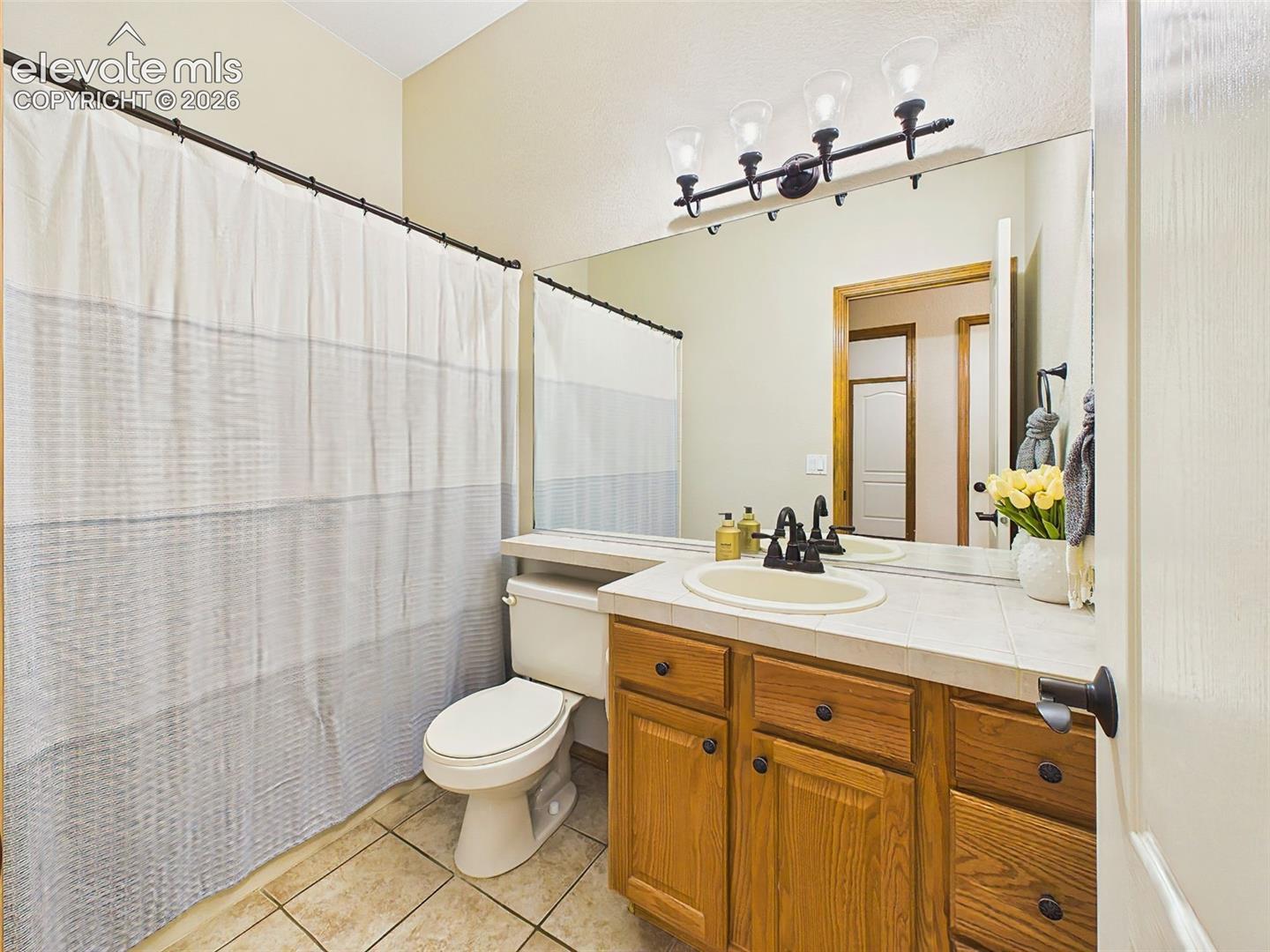 Well-maintained full bath with tile countertops, and a convenient tub/shower combination.