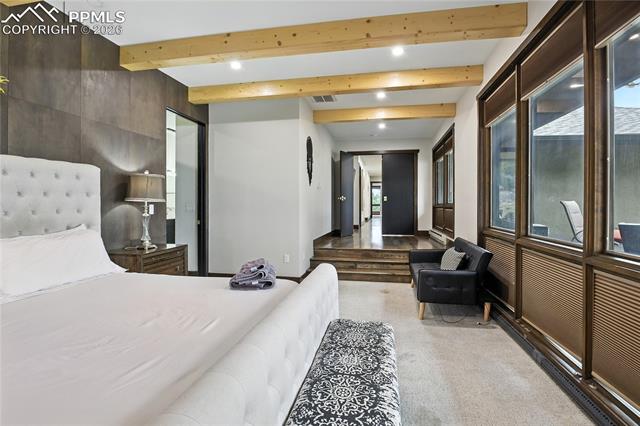 Bedroom featuring beamed ceiling, light colored carpet, and recessed lighting