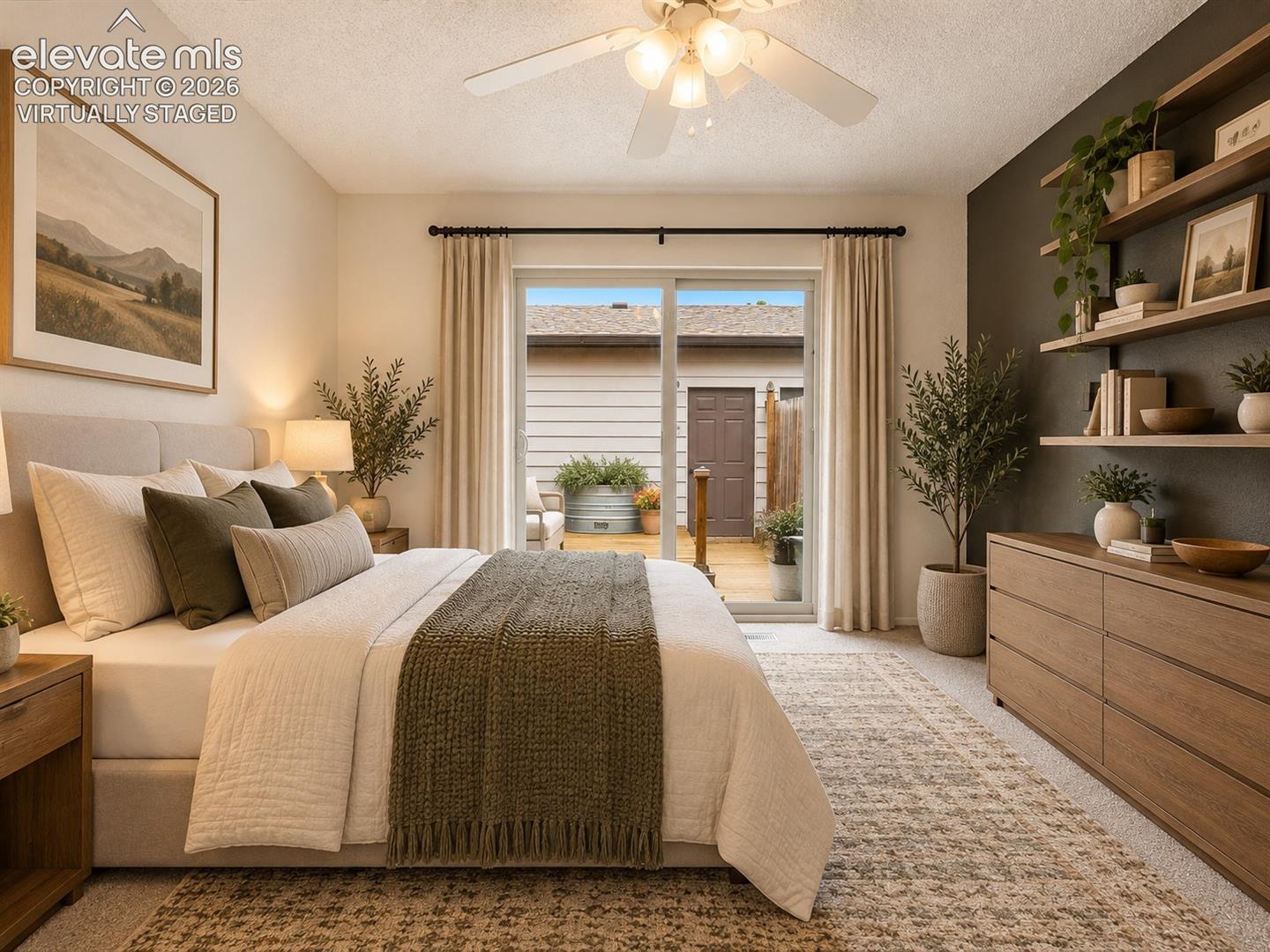 Sliding glass door, wall-mounted floating wood shelving, neutral wall-to-wall carpeting, and a ceiling-mounted light fixture with a multi-blade fan- virtually staged