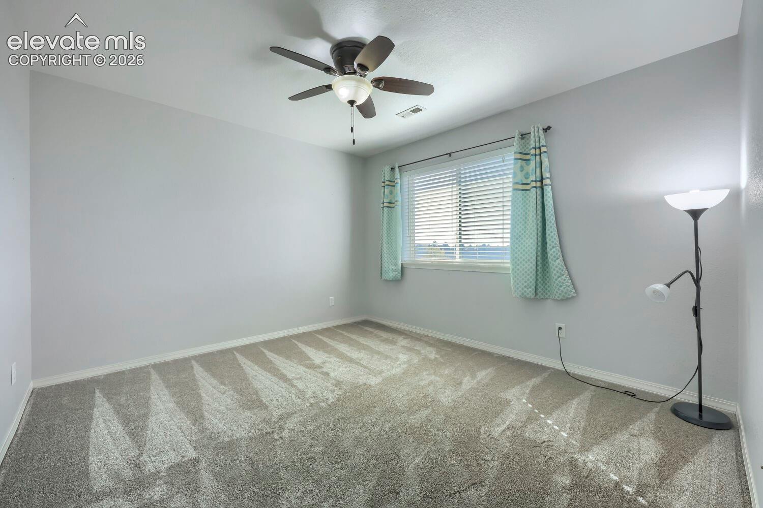 Room featuring neutral wall tones, wall-to-wall carpeting, and a ceiling fan with integrated lighting